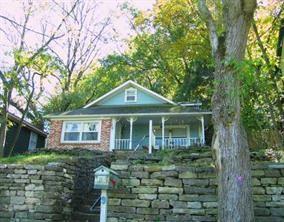 View of house with stone wall at front of lot